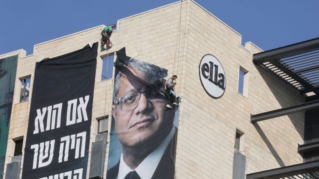 FILE PHOTO: Workers remove a banner featuring an image of Israel's National Security Minister Itamar Ben-Gvir, in Jerusalem