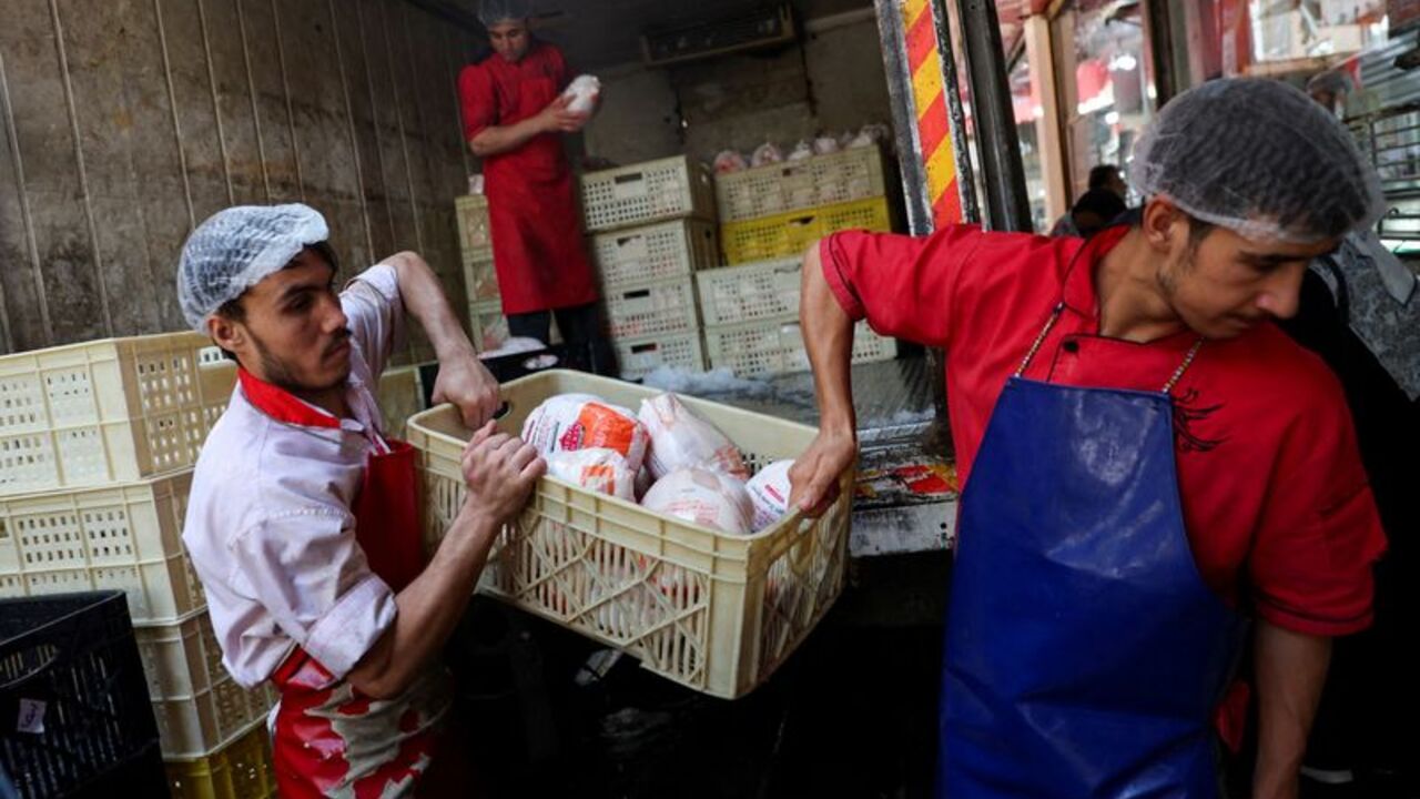 People work in a butcher shop in Tehran