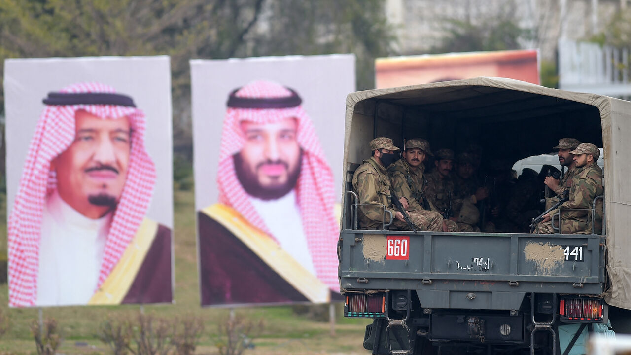 Pakistani soldiers (R) patrol on a street next to welcoming posters of Saudi Arabian Crown Prince Mohammed bin Salman in Islamabad on Feb. 17, 2019.