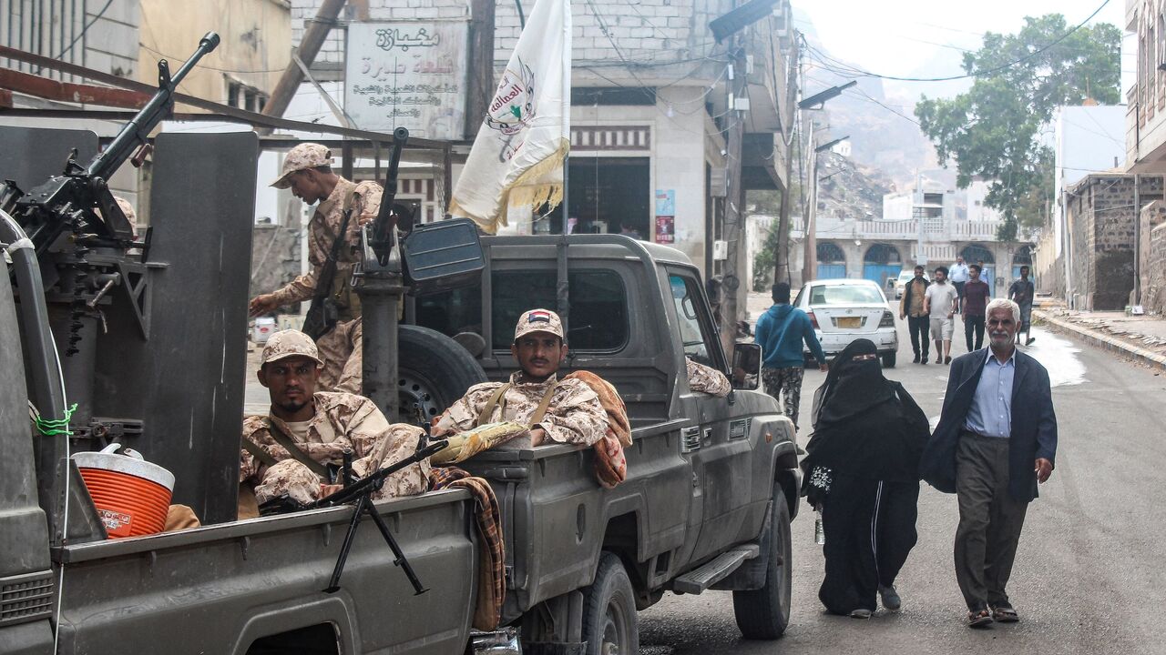 Members of the Southern Giants Brigade sit in the back of military vehicles