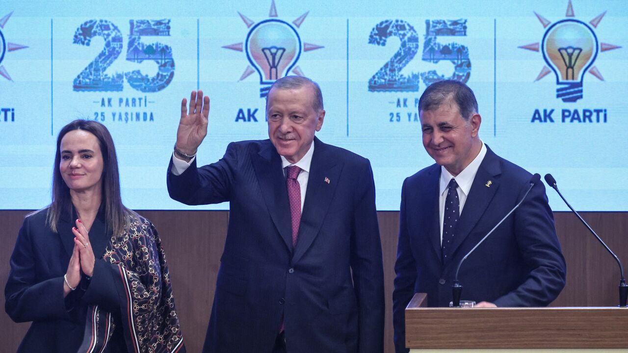 Izmir Mayor Cemil Tugay (R) his wife Oznur Tugay and Turkish President Recep Tayyip Erdogan acknowledge the audience after the mayor announced joining the ruling Justice and Development Party during a meeting with AKP lawmakers in Ankara, on Oct. 7, 2026. 