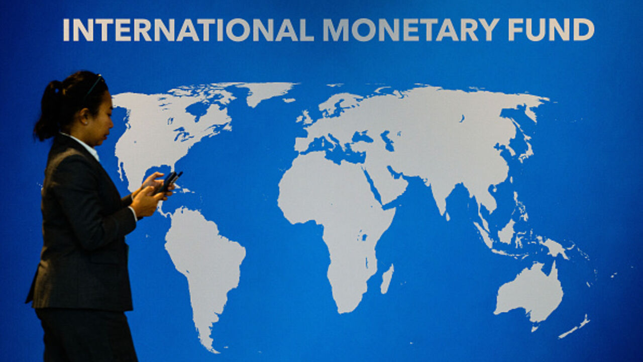 An attendee walks past signage displayed inside the venue for the Annual Meetings of the International Monetary Fund (IMF) and the World Bank Group (WBG) at the Queen Sirikit National Convention Center (QSNCC) in Bangkok on October 14, 2026. (Photo by ANTHONY WALLACE / AFP via Getty Images)