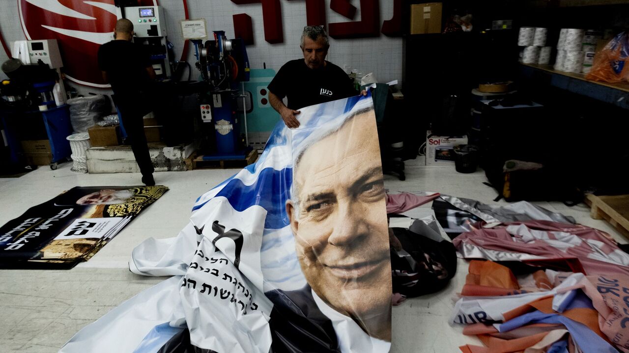 A print house worker produces a campaign poster showing Israeli Prime Minister Benjamin Netanyahu