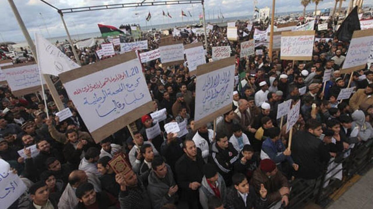 People carrying banners demand that the Libyan National Transitional Council apply Islamic sharia rule in the country and declare Islam the state religion, in Benghazi January 20, 2012. Hundreds of Libyan Islamists rallied on Friday to demand that Muslim sharia law inspire legislation in what organisers called a response to the emergence of secular political parties after the fall of Muammar Gaddafi's dictatorship last year.  REUTERS/Esam Al-Fetori (LIBYA - Tags: POLITICS RELIGION)