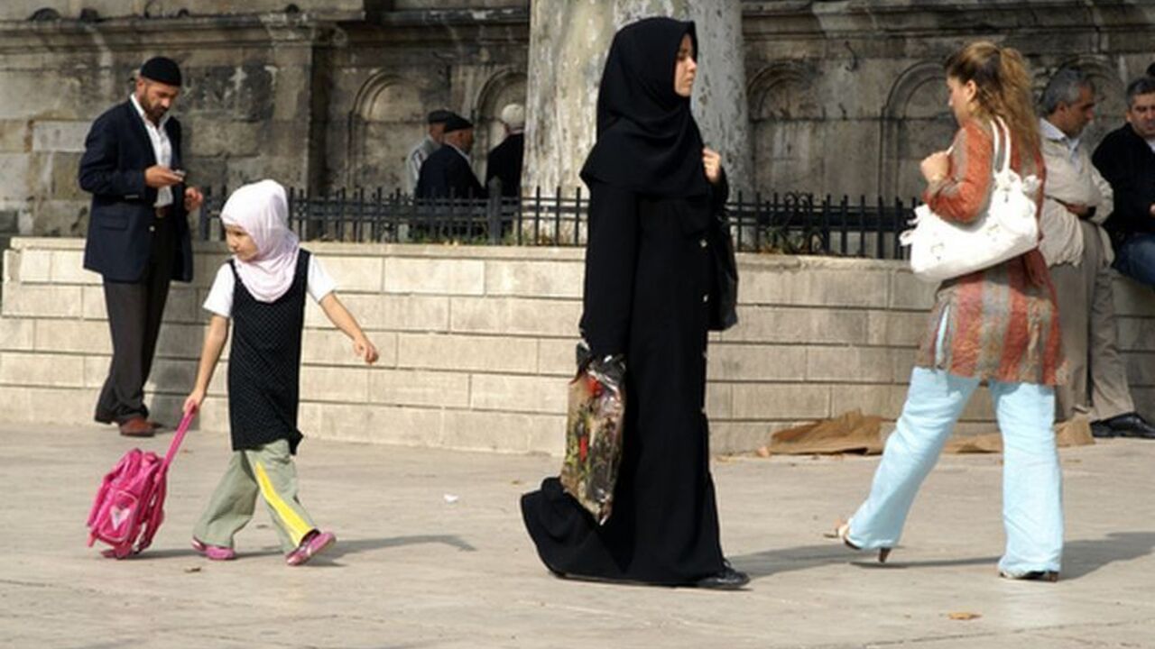 A mother and her covered child pass a secular woman outside Fatih Mosqe in central Istanbul on Saturday October 6, 2007. Women's rights groups have been angered after a leaked draft of the new constitution states that it will change " The present constitution obliges the government to ensure equality for all - a clause that women's groups fought hard to include. The new draft removes that, and describes women as a vulnerable group in need of special protection. The new constitution will also likely lift the