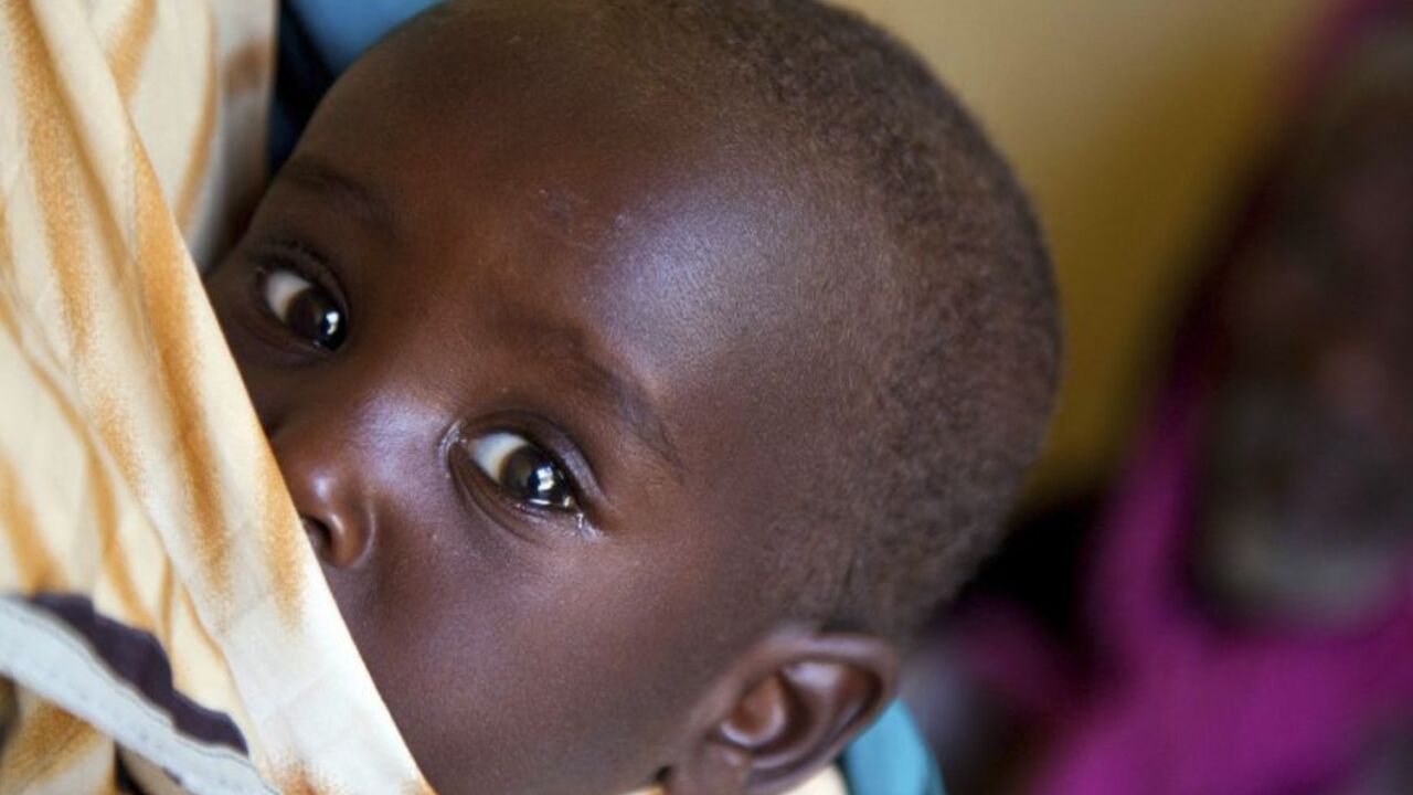 A baby is carried as women and children residents wait to be examined by doctors in Kassab camp for Internally Displaced Persons (IDP), in Kutum, North Darfur August 9, 2012. Gunmen surrounded a camp for displaced people in Kassab in North Darfur state, burnt down a police station and looted the main market, African Union/United Nations peacekeepers UNAMID said in a statement. UNAMID said it had received reports that four people had been killed and six injured during the incident on August 1. REUTERS/Albert