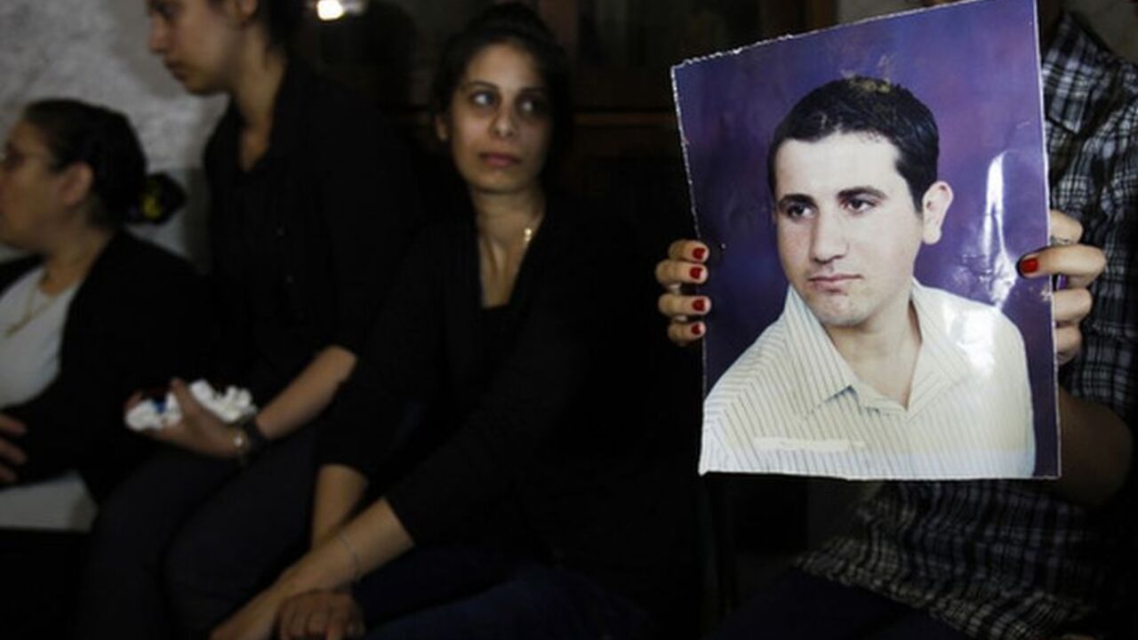 A Palestinian Christian holds a picture depicting Ramez al-Amash who they claim was forced to convert to Islam, during a protest at the Saint Porfirios church in Gaza City July 17, 2012. Two conversions that a Christian family says were forced have strained relations between a tiny Palestinian Christian community in the Hamas-run Gaza Strip and the Muslim majority. Picture taken July 17, 2012. To match Feature PALESTINIANS-CHRISTIANS/CONVERSION REUTERS/Ibraheem Abu Mustafa (GAZA - Tags: RELIGION POLITICS)
