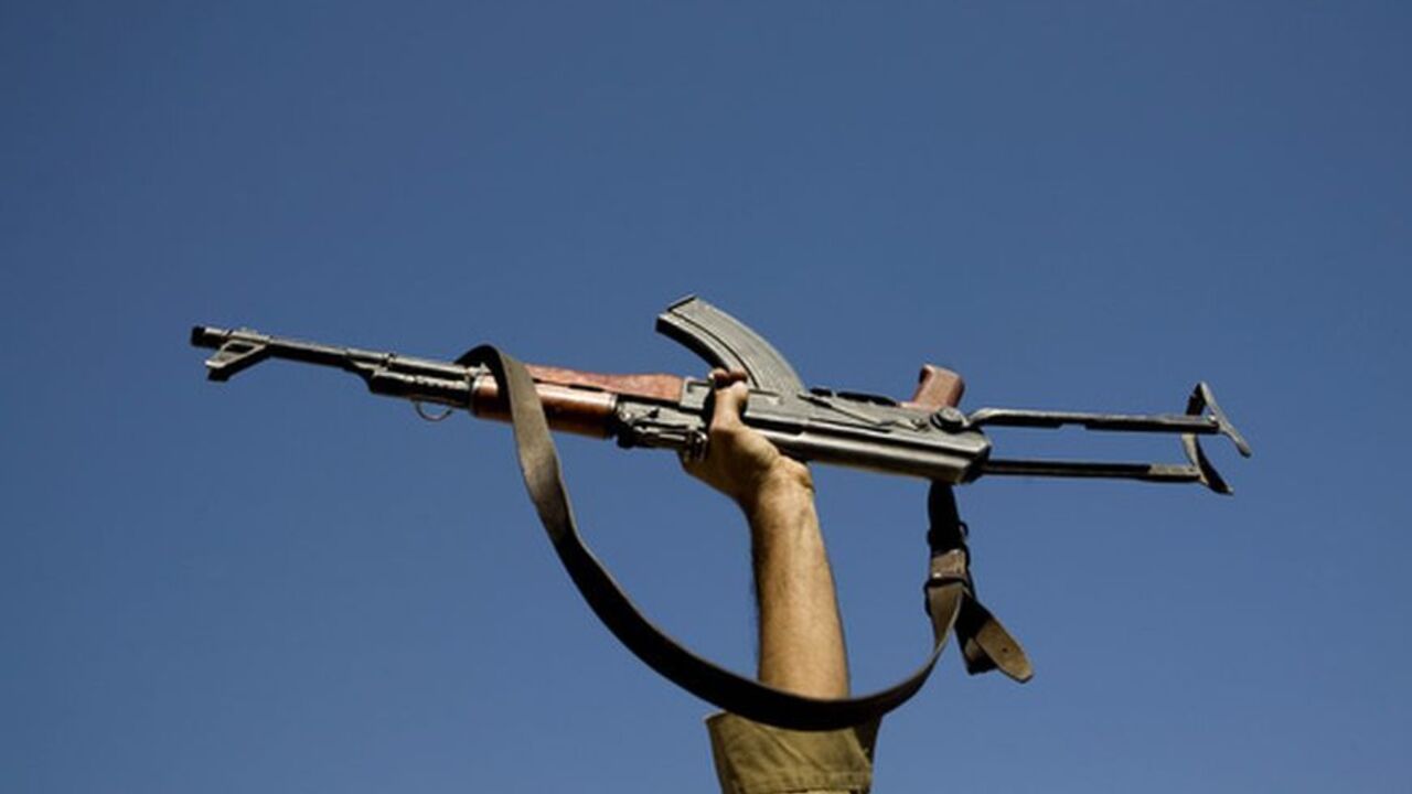 An actor holds up his gun during filming of an Iranian film directed by Sadegh Karamyar about the Iran-Iraq war (1980-88) on a film set about 25km (15 miles) south of Tehran September 25, 2007. REUTERS/Morteza Nikoubazl (IRAN)