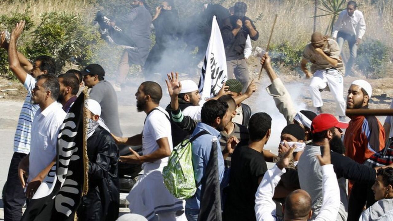 Protesters run for cover during a demonstration in front of the U.S. Embassy in Tunis September 14, 2012. At least five protesters were wounded when Tunisian police opened fire on Friday to quell an assault on the U.S. embassy compound in the capital Tunis, a Reuters reporter said. It was not immediately clear if police fired live rounds or rubber bullets. A large fire erupted inside the compound which has been invaded by hundreds of people incensed by a U.S.-made film that demeans the Prophet Mohammad. REU