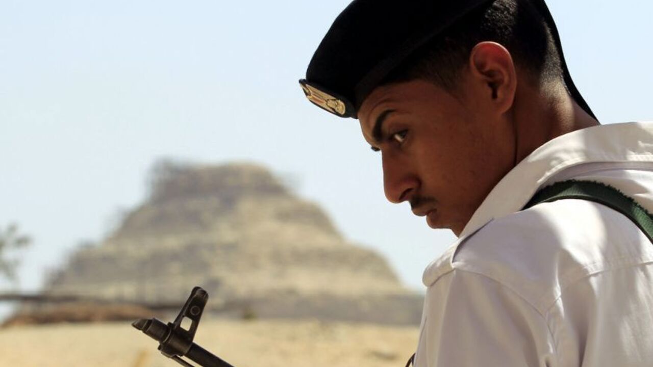 A soldier stands guard with his weapon at the main gate leading to the Saqqara or "Step" Pyramid, south of Cairo, September 20, 2012. Egypt's antiquities authority reopened the "Serapeum" and "Akhethotep & Ptahhotep" tombs near the Saqqara Pyramid on Thursday, after the ancient tombs had undergone ten years of renovations, with an estimated cost of 2 million dollars. REUTERS/Mohamed Abd El Ghany (EGYPT - Tags: TRAVEL SOCIETY)