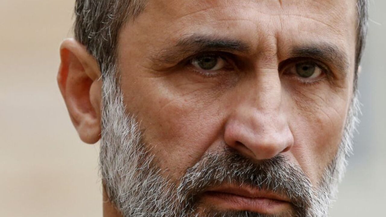 New Syrian National Coalition head Mouaz al-Khatib listens as France's President speaks to journalists in the courtyard following a meeting at the Elysee Palace in Paris, November 17, 2012.   REUTERS/Benoit Tessier (FRANCE  - Tags: POLITICS HEADSHOT)