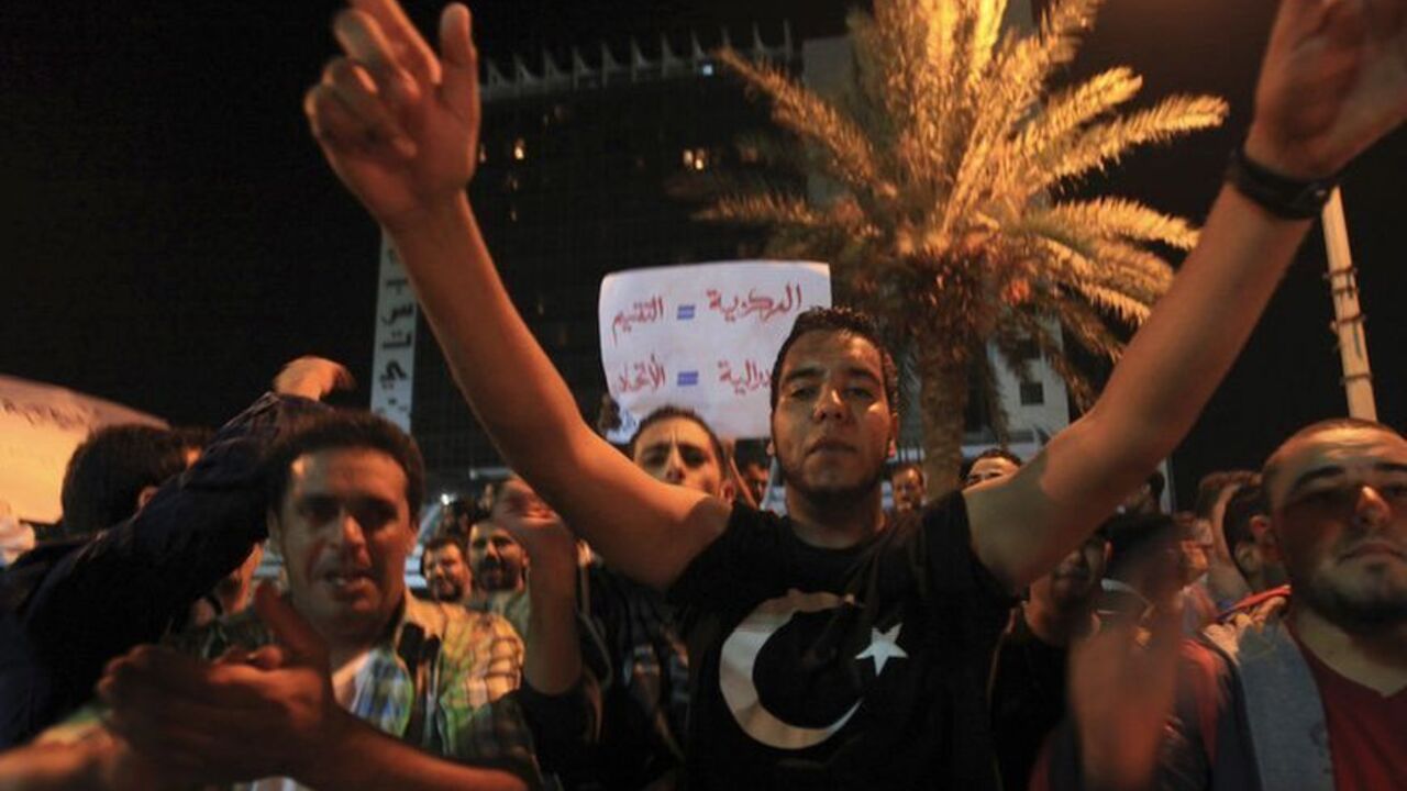 A man wearing a T-shirt bearing a flag of the Emirate of Cyrenaica (C) attends a protest demanding federal governance and a branch of the National Oil Corporation to be set up in the country's second-largest city, in Benghazi November 26, 2012. Libya's National Oil Corporation (NOC) is reviewing a proposal for a Benghazi branch as officials contend with opposition by NOC staff in Tripoli versus protests and threats of output cuts by workers in the oil-rich east who want more control there. Benghazi was the 