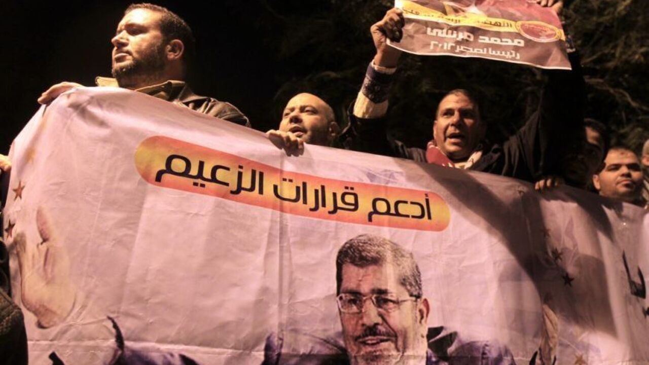 Supporters of Egyptian President Mohammed Mursi hold a banner reading: "Yes for the President's decisions" outside the presidential palace in Cairo December 5, 2012. Islamists fought protesters outside the Egyptian president's palace on Wednesday, while inside the building his deputy proposed a way to end a crisis over a draft constitution that has split the most populous Arab nation. REUTERS/Mohamed Abd El Ghany (EGYPT - Tags: POLITICS CIVIL UNREST)
