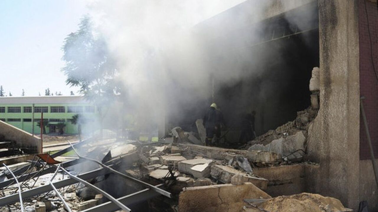Firefighters stand among debris after bombs exploded in a school building in Damascus September 25, 2012 in this handout photograph released by Syria's national news agency SANA. Bombs planted by rebels exploded at the school building occupied by security forces and pro-government militias in the Syrian capital of Damascus on Tuesday, activists and rebels said.   REUTERS/SANA (SYRIA - Tags: POLITICS CIVIL UNREST) FOR EDITORIAL USE ONLY. NOT FOR SALE FOR MARKETING OR ADVERTISING CAMPAIGNS. THIS IMAGE HAS BEE