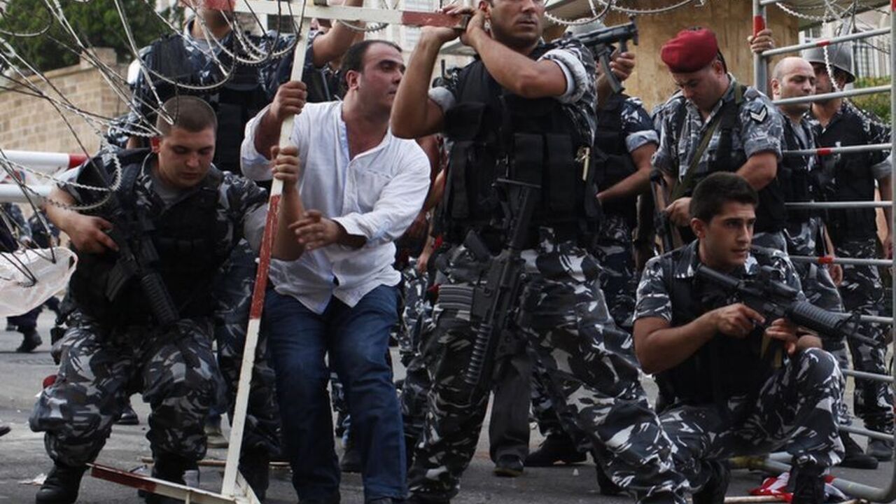 Lebanese security forces reinforce the barriers during clashes with protesters who were trying to storm the Lebanese government in Beirut October 21, 2012. Angry mourners marched on Lebanese Prime Minister Najib Mikati's offices in central Beirut on Sunday, breaking through an outer security barrier and scuffling with police who fired tear gas in response. "Mikati leave, get out," chanted hundreds of protesters following the funeral of a slain intelligence chief. REUTERS/Ahmed Jadallah (LEBANON- Tags: POLIT