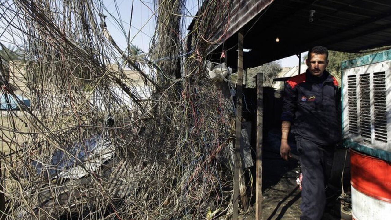 An electrician walks past wires connected to a local generator in Baghdad January 23, 2011. Iraq is slowly getting back on its feet after decades of war and economic sanctions, but a chronic power shortage is hobbling the development of local industry just when it is needed most. An unemployment rate that some officials say runs at 30 percent represents not just an economic challenge but also provides muscle for a lingering insurgency as the sectarian warfare unleashed after the 2003 U.S.-led invasion fades