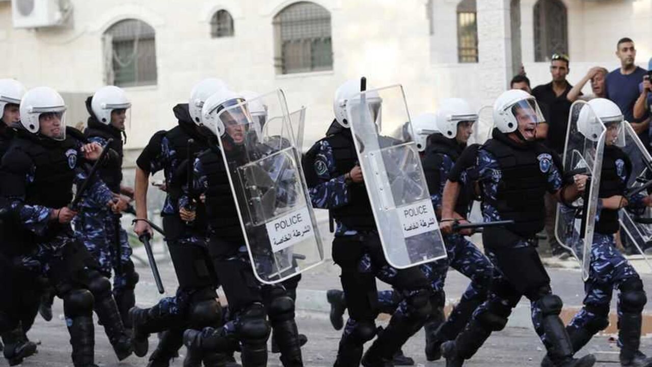 Palestinian police officers charge towards protesters during clashes at a demonstration against high living costs and the government in the West Bank city of Hebron September 10, 2012. Palestinian youths attacked a local police station and other government buildings in Hebron on Monday as protests against the rising cost of living in the occupied West Bank turned increasingly violent. R   EUTERS/Darren Whiteside (WEST BANK - Tags: POLITICS CIVIL UNREST)