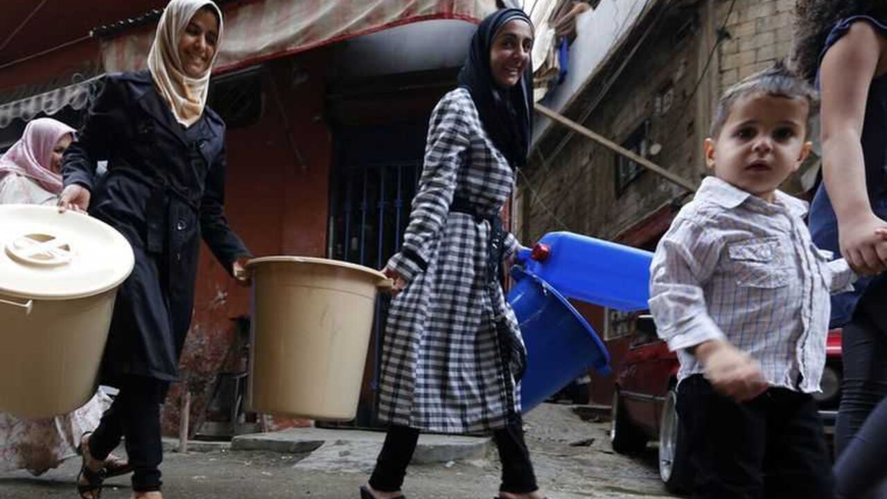 Syrian refugees carry tools donated by humanitarian activists on the first day of Eid al-Adha in Beirut October 26, 2012. Muslims around the world celebrate Eid al-Adha, marking the end of the haj, by slaughtering sheep, goats, cows and camels to commemorate Prophet Abraham's willingness to sacrifice his son Ismail on God's command. REUTERS/Jamal Saidi    (LEBANON - Tags: RELIGION SOCIETY)