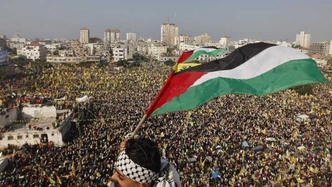 A boy waves a Palestinian flag during a rally marking the 48th anniversary of the founding of the Fatah movement, in Gaza City January 4, 2013. Hundreds of thousands of Palestinians joined a rare rally staged by President Mahmoud Abbas's Fatah group in Gaza on Friday, as tensions ease with rival Hamas Islamists ruling the enclave since 2007. REUTERS/Mohammed Salem (GAZA - Tags: POLITICS ANNIVERSARY) - RTR3C3GR