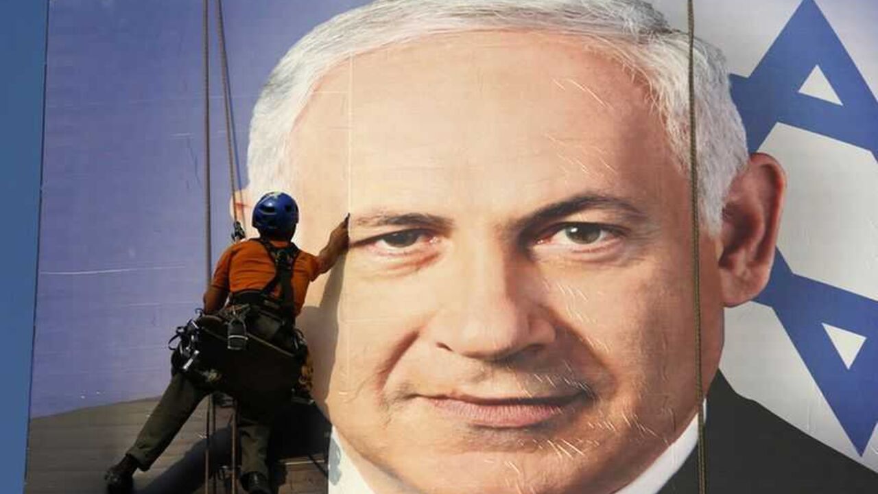 A worker installs a banner depicting Israel's Prime Minister Benjamin Netanyahu in Tel Aviv January 17, 2013. Netanyahu looks set to form a new governing coalition after next week's election, polls show, with the only question being whether he wants to soften its hardline contours. REUTERS/Baz Ratner (ISRAEL - Tags: POLITICS ELECTIONS TPX IMAGES OF THE DAY)