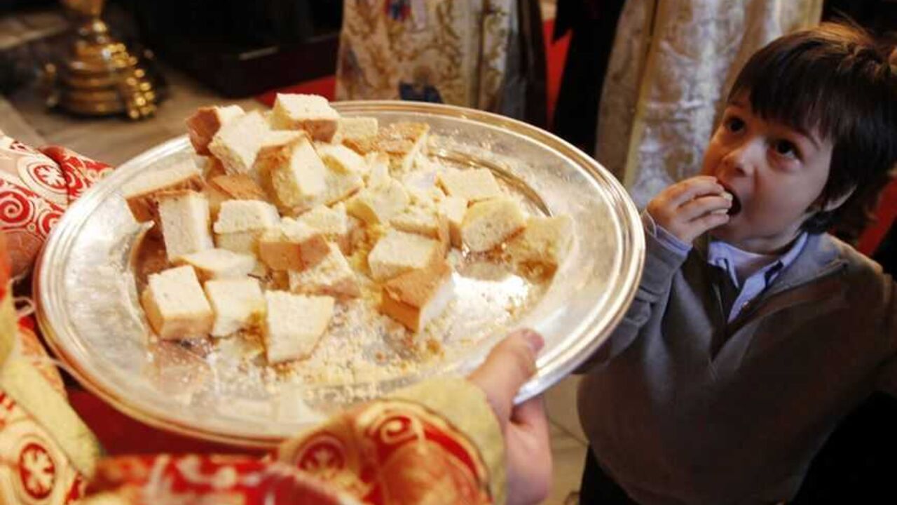 Yorgo Diagurisi, a four-year-old Greek Orthodox boy, eats bread during a Christmas mass at the Greek Orthodox patriarchal cathedral of St. George in Istanbul December 25, 2010. REUTERS/Murad Sezer (TURKEY - Tags: RELIGION SOCIETY)