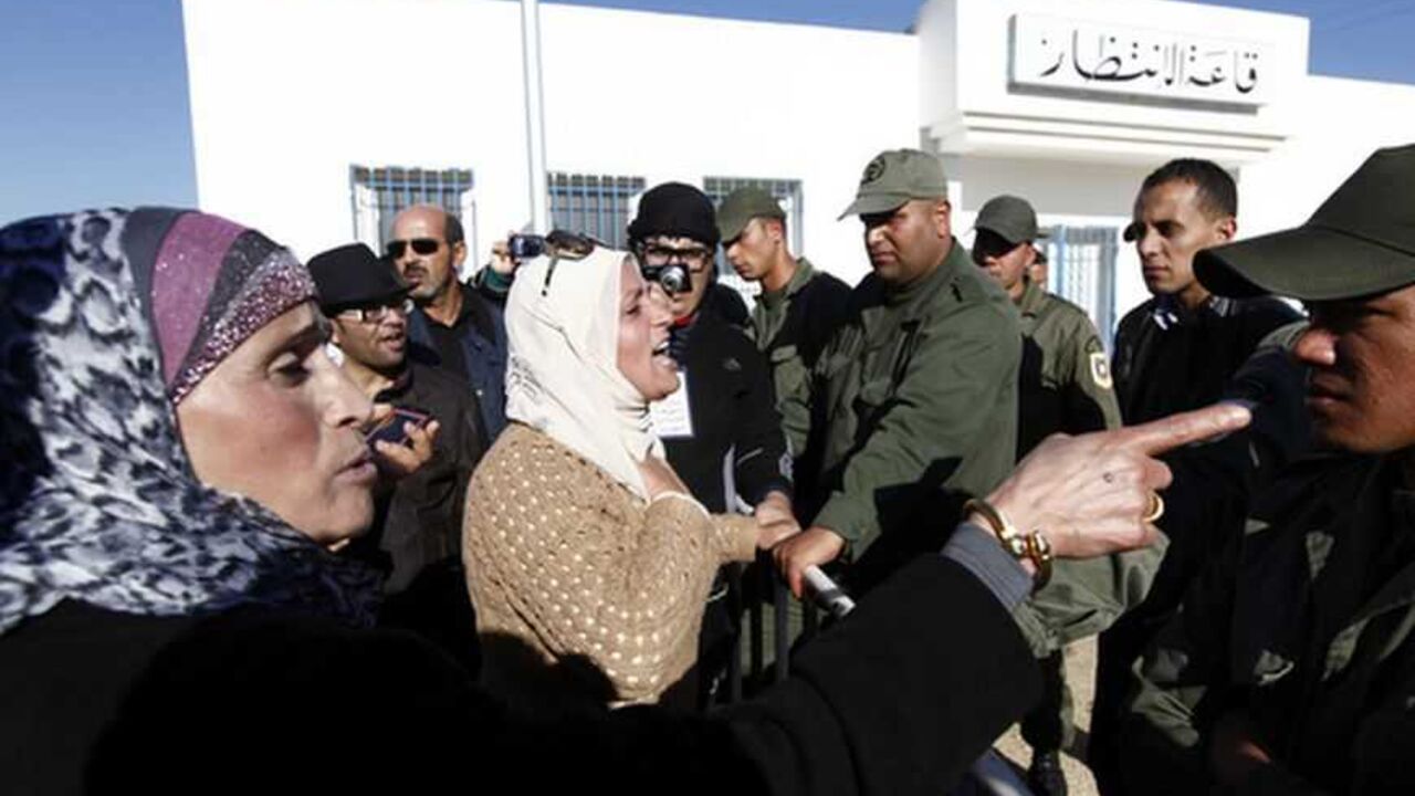 A Tunisian protester gestures towards a police officer during a demonstration outside Mornaguia jail calling for the liberation of Sami Fehri, TV producer and director of Ettounsiya Television, in Tunis December 24, 2012. REUTERS/Anis Mili  (TUNISIA - Tags: POLITICS CIVIL UNREST SOCIETY)