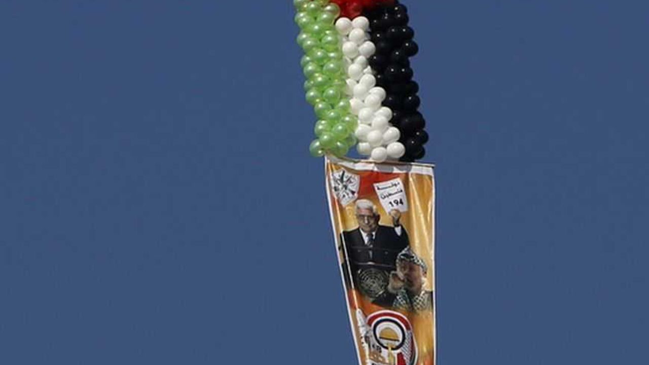 A balloon attached to a poster depicting Palestinian President Mahmoud Abbas and late Palestinian leader Yasser Arafat flies during a rally marking the 48th anniversary of the founding of the Fatah movement, in Gaza City January 4, 2013. Hundreds of thousands of Palestinians joined a rare rally staged by President Mahmoud Abbas's Fatah group in Gaza on Friday, as tensions ease with rival Hamas Islamists ruling the enclave since 2007. REUTERS/Suhaib Salem (GAZA - Tags: POLITICS ANNIVERSARY)