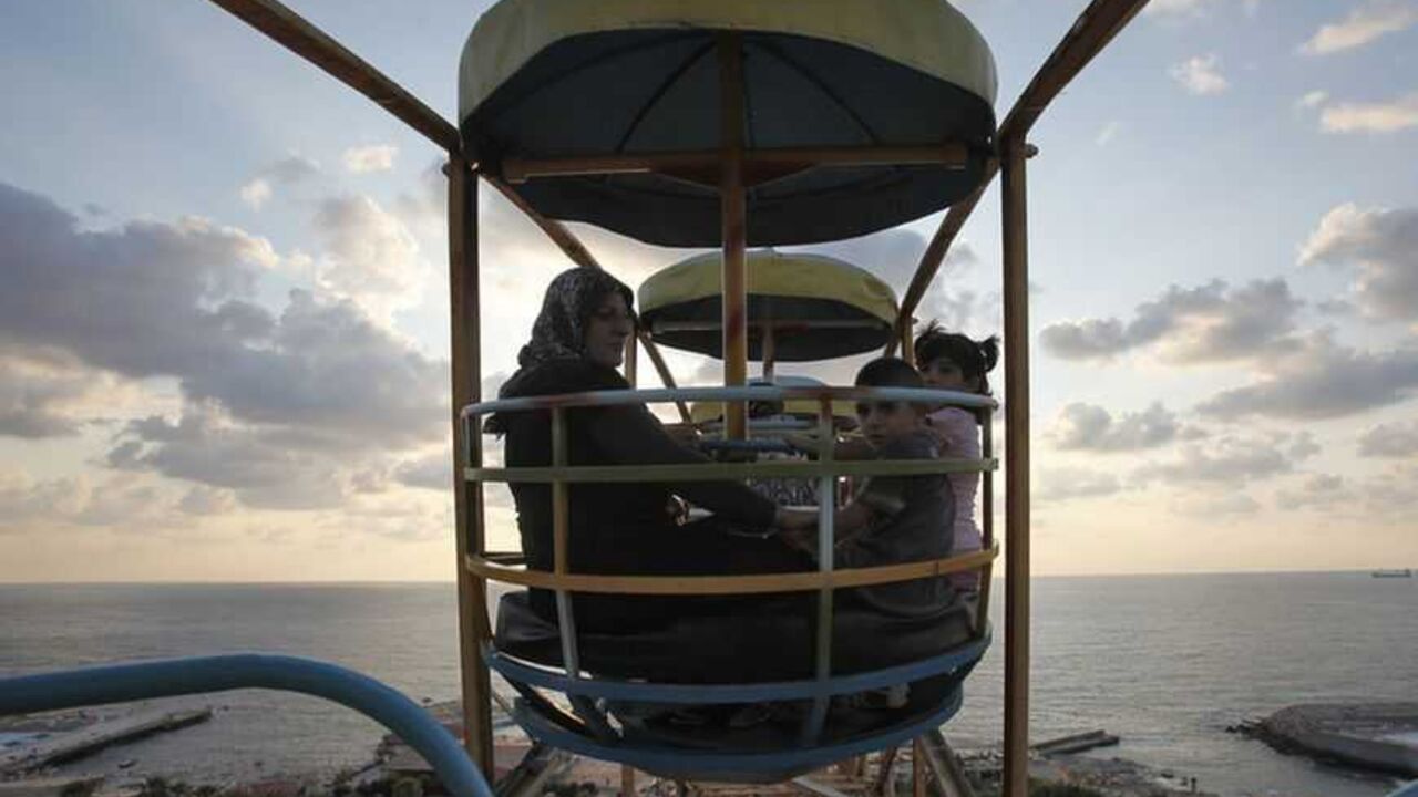 A Muslim family enjoy a ride on a ferris wheel at an amusement park during Eid al-Fitr in Beirut August 30, 2011. Muslims around the world celebrate Eid al-Fitr to mark the end of Ramadan, the holiest month in the Islamic calendar.   REUTERS/Cynthia Karam    (LEBANON - Tags: RELIGION) - RTR2QK5N