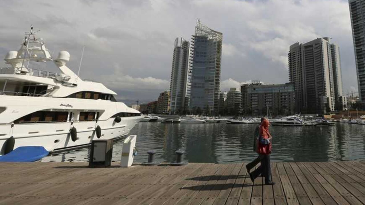 A couple are seen walking at Zaytouna Bay in Beirut October 25, 2012. The party capital of the Arab world, Beirut is a freewheeling city where Gulf Arabs, expatriates and Lebanese emigres fly in to enjoy its luxury hotels. But under the veneer of modernity lie sectarian demons coiled to strike. The car-bomb assassination last Friday of intelligence chief Wissam al-Hassan - an attack almost universally blamed on Syria and its local allies - brought the merry-go-round to a juddering halt. Gunmen and protester