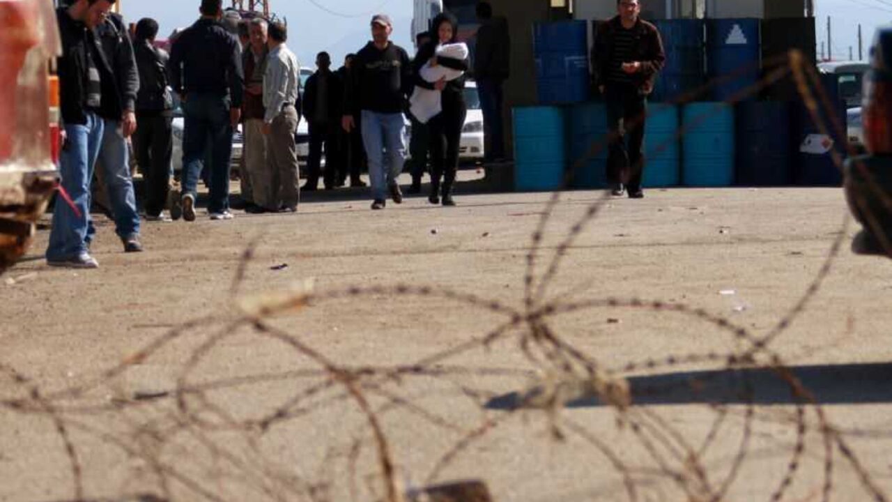 People cross the Lebanese-Syrian border by foot after residents blocked the road in protest against what they said were the sending of diesel to the Syrian goverment, in northern Lebanon February 13, 2013. REUTERS/Omar Ibrahim (LEBANON - Tags: POLITICS CIVIL UNREST) - RTR3DQO6
