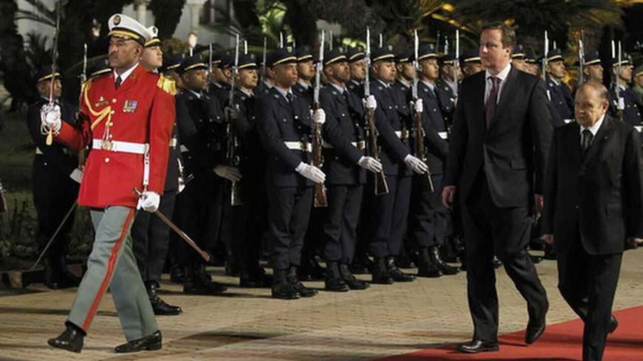 Algerian President Abdelaziz Bouteflika (R) and British Prime Minister David Cameron (2nd R) review the honour guard during a welcoming ceremony at the Presidential Palace in Algiers January 30, 2013.  REUTERS/Louafi Larbi (ALGERIA - Tags: POLITICS) - RTR3D62J