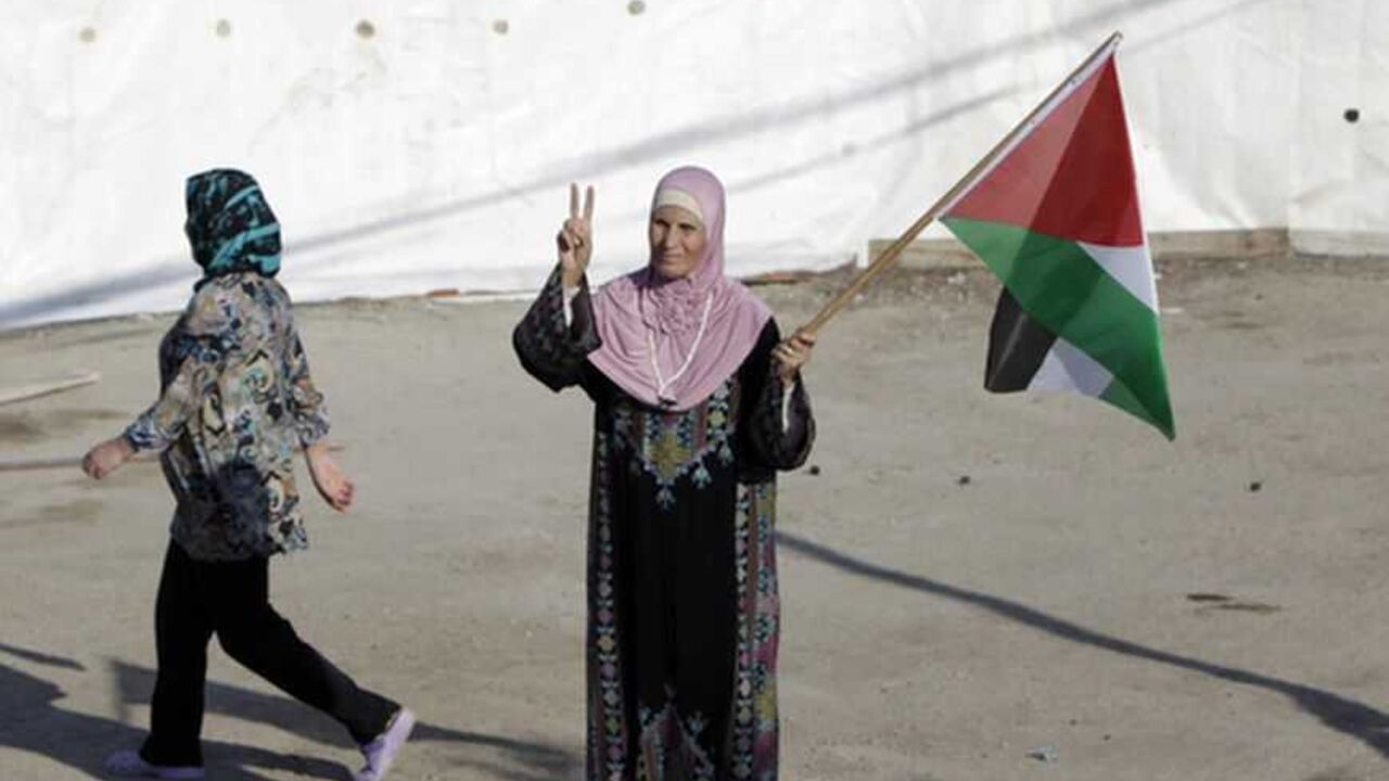 Rukia, the mother-in-law of Palestinian prisoner Ibtisam Issawi, holds a flag outside her home in the Arab East Jerusalem neighbourhood of Jabal Mukaber October 17, 2011, as the family prepares for the release of Issawi in a prisoner swap that is expected to take place on Tuesday. Israel and Gaza's Hamas Islamist rulers have agreed to swap 1,027 Palestinian prisoners in return for Israeli soldier Gilad Shalit, who has been held captive in Gaza since 2006. REUTERS/Ammar Awad (JERUSALEM - Tags: POLITICS CIVIL