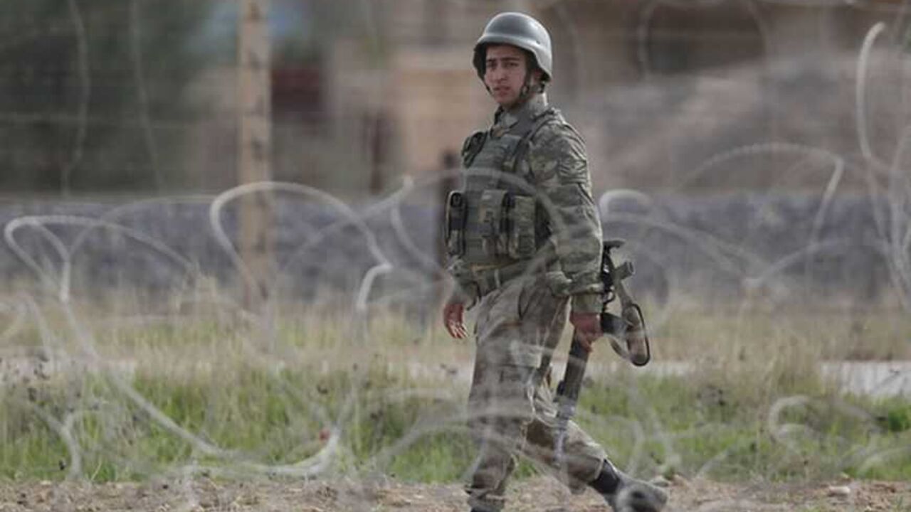 A Turkish soldier walks on the Turkish-Syrian border in Ceylanpinar, southern Sanliurfa province November 13, 2012. A Syrian warplane struck homes in the town of Ras al-Ain on Tuesday within sight of the Turkish border, pursuing an aerial bombardment to force out rebels, a Reuters witness and refugees said.The second day of jet strikes sent Syrians scurrying through the flimsy barbed-wire fence that divides Ras al-Ain from the Turkish settlement of Ceylanpinar, thick plumes of smoke rising above the town. R