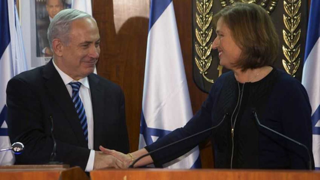 Israel's Prime Minister Benjamin Netanyahu (L) shakes hands with former Foreign Minister Tzipi Livni, head of the centrist Hatenuah party, during their joint statement at the Knesset, the Israeli parliament, in Jerusalem February 19, 2013. Netanyahu took his first step in forming a new government on Tuesday saying he had signed a coalition deal with Livni, who will handle efforts to renew stalled Middle East diplomacy. REUTERS/Ronen Zvulun (JERUSALEM - Tags: POLITICS) - RTR3DZYL