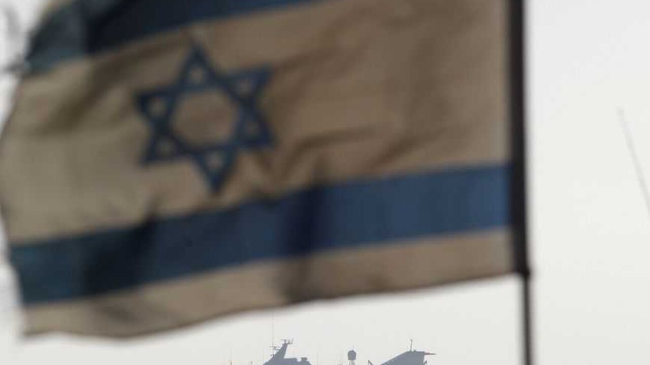 An Israeli flag flutters in the wind as a naval vessel (not seen) escorts the Mavi Marmara, a Gaza-bound ship that was raided by Israeli marines, to the Ashdod port May 31, 2010. Israeli marines stormed the Turkish aid ship bound for Gaza on Monday and 10 pro-Palestinian activists were killed, triggering a profound diplomatic crisis. REUTERS/Amir Cohen (ISRAEL - Tags: POLITICS CIVIL UNREST IMAGES OF THE DAY) - RTR2ELLI