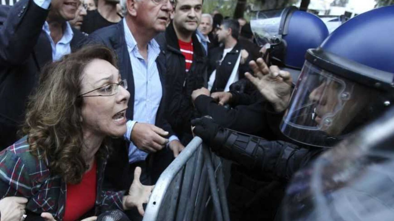 A protester yells at policemen during a protest by employees of Cyprus Popular Bank outside the parliament in Nicosia March 21, 2013. The Cypriot central bank denied reports and frantic rumours on Thursday that stricken Cyprus Popular Bank, the island's second-largest lender, is to be closed down.        REUTERS/Andreas Manolis  (CYPRUS - Tags: POLITICS BUSINESS CIVIL UNREST TPX IMAGES OF THE DAY) - RTR3FA5X