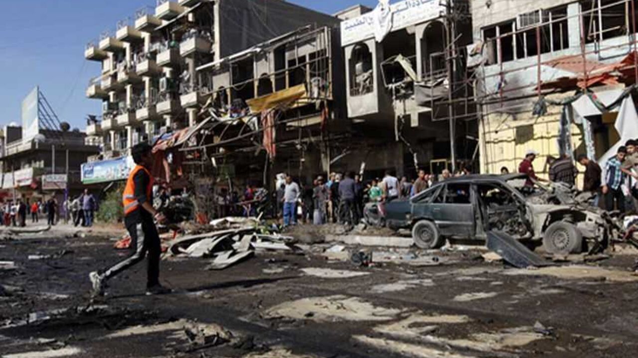 Residents gather at the site of a car bomb attack in the AL-Mashtal district in Baghdad March 19, 2013. A series of coordinated car bombs and blasts hit Shi'ite districts across Baghdad and south of the Iraqi capital on Tuesday, killing at least 25 people on the tenth anniversary of the U.S.-led invasion. REUTERS/Mohammed Ameen (IRAQ - Tags: CONFLICT CIVIL UNREST) - RTR3F6F7