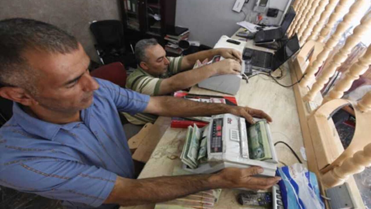 Men count wads of Iraqi dinars using money counting machines at a currency exchange shop in Baghdad October 1, 2012. Many Iraqis have lost faith in their dinar currency but to some foreign speculators, it promises big profits. The contrast underlines the uncertainties of investing in Iraq as the country recovers from years of war and economic sanctions. Picture taken October 1, 2012. To match IRAQ-ECONOMY/DINAR REUTERS/Saad Shalash (IRAQ - Tags: BUSINESS POLITICS) - RTR38QU4