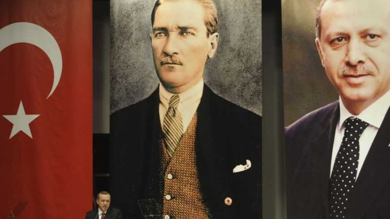 Turkey's Prime Minister Recep Tayyip Erdogan addresses the members of his ruling AK Party, as he stands in front of the portraits of Mustafa Kemal Ataturk, founder of modern Turkey, and himself during a meeting at his party headquarters in Ankara October 26, 2011. REUTERS/Stringer (TURKEY - Tags: POLITICS) - RTR2T7L8