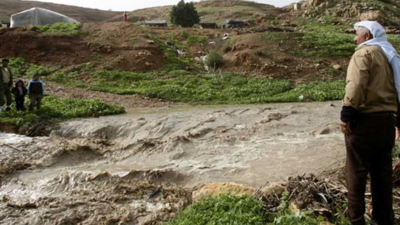 Palestinians look at water in an overflowing stream in the West Bank village of Al-Nassariyeh near Nablus January 8, 2013. REUTERS/Abed Omar Qusini (WEST BANK - Tags: ENVIRONMENT) - RTR3C7WK