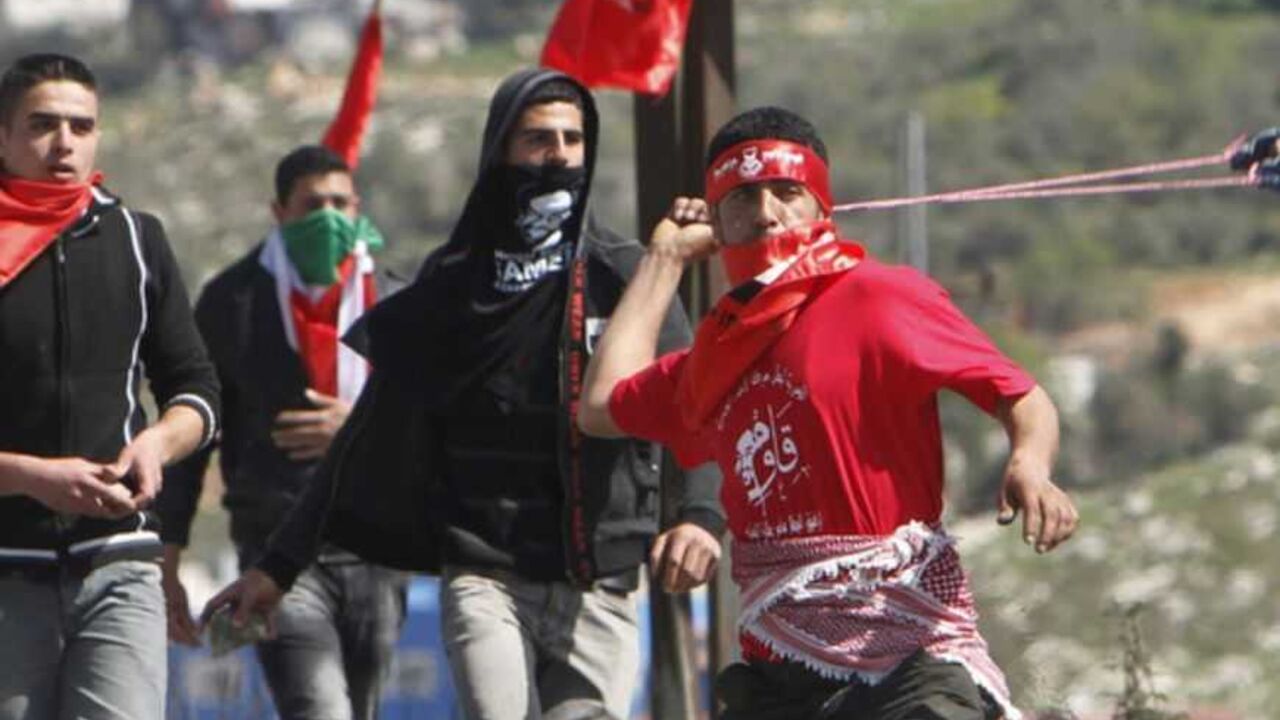 Palestinian protesters throw stones towards Israeli forces during clashes at Hawara checkpoint near the West Bank city of Nablus March 2, 2013. The death of a Palestinian prisoner in disputed circumstances in an Israeli jail last week, together with a hunger strike by four other Palestinian inmates, two of whom ended their protest on Wednesday after an agreement on their release was reached with Israel, have touched off violent protests over the past several weeks in the West Bank. REUTERS/Abed Omar Qusini 