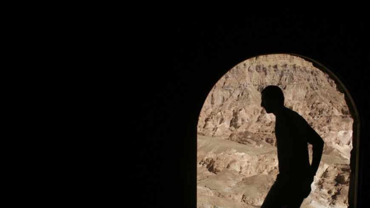A Bedouin stands in front of a coffee shop overlooking Coloured Canyon in the Sinai Peninsula near the town of Nuweiba March 2, 2007. The 800 metre (0.5 miles) long rock formation consists of sandstone, limestone, granite and veins of basalt.      REUTERS/Goran Tomasevic        (EGYPT) - RTR1N0X1