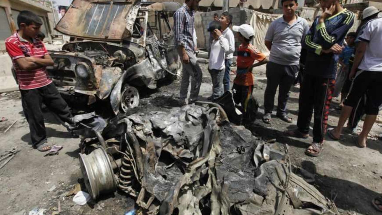 Residents gather at the site of a car bomb attack in the Kamaliya district in Baghdad April 15, 2013. Car bombs and attacks on cities across Iraq, including two blasts at a checkpoint at Baghdad international airport, killed at least 20 people and wounded more than 200 on Monday, police said. The wave of attacks in Baghdad, Kirkuk, Tuz Khurmato and other towns to the north to south, came days before Iraqis vote in provincial elections that will test political stability more than a year after U.S. troops lef