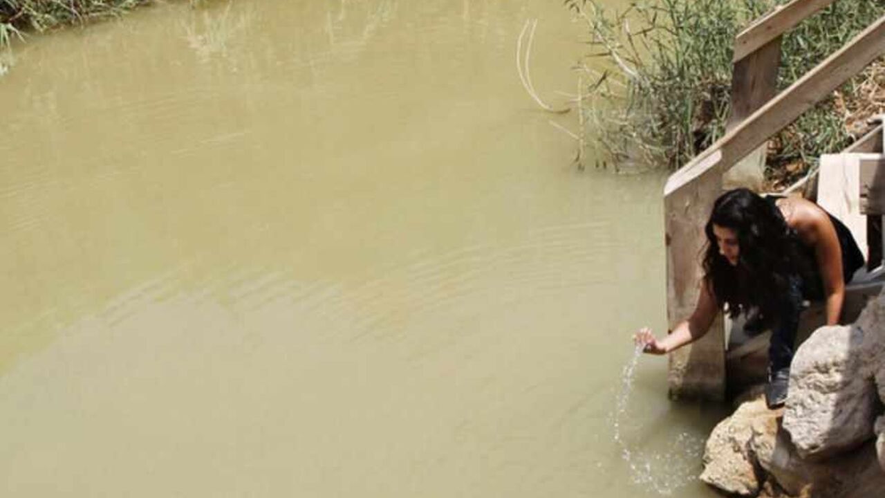 A Jordanian visitor scoops up water along the Jordanian side of the Jordan River August 3, 2010. The Baptism Site Commission of Jordan's director Dia Al Madani told Reuters TV on Tuesday they had not received complaints by Christian pilgrims that the water caused any type of ailment, or skin disease. Madani insisted that thousands who come to be baptised every month, do not suffer any side effects on their health. Jordanian officials have refuted recent press reports that the water of the Jordan River was h
