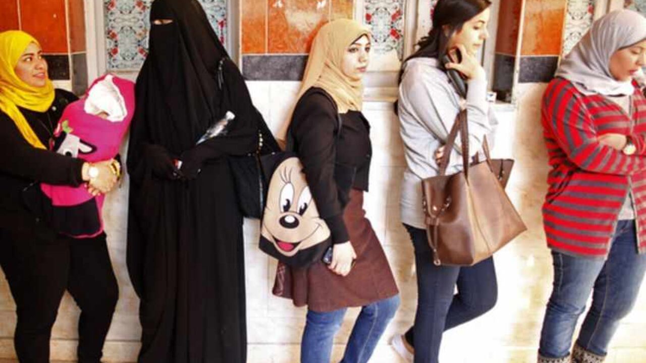 Women queue at a polling station to vote in the second and final round of a referendum on Egypt's new constitution, in Giza, south of Cairo, December 22, 2012. Egyptians voted on a constitution drafted by Islamists on Saturday in a second round of balloting expected to approve the charter that opponents say will create deeper turmoil in Egypt. REUTERS/Khaled Abdullah (EGYPT - Tags: POLITICS ELECTIONS) - RTR3BUBZ