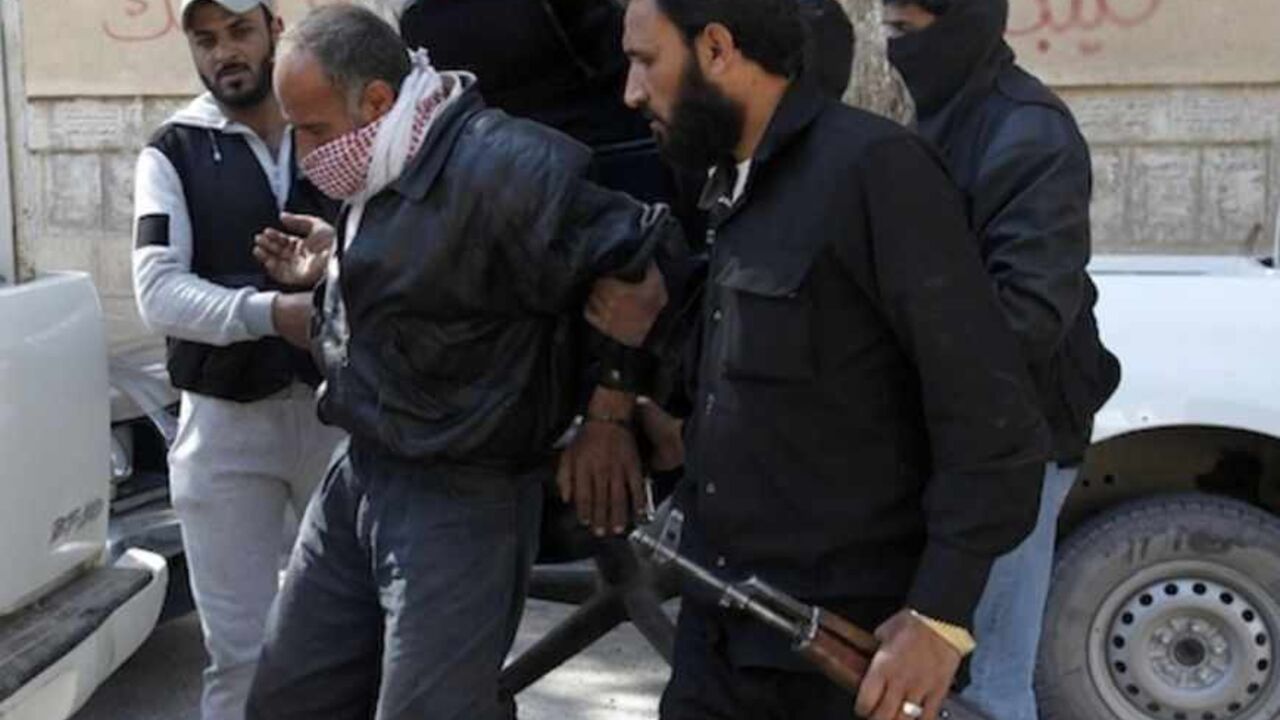 Members of Islamist Syrian rebel group Jabhat al-Nusrain hold a detainee as they transport him in Raqqa province, eastern Syria, March 14, 2013. REUTERS/Hamid Khatib (SYRIA - Tags: CONFLICT POLITICS) - RTR3EZGD