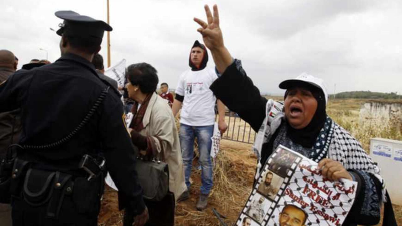 A Palestinian protester holds a placard during a demonstration in support of hunger-striking Palestinian prisoner Samer al-Issawi, outside Kaplan hospital in Rehovot near Tel Aviv April 22, 2013. Some 20 protesters demonstrated on Monday outside the hospital treating al-Issawi as Palestinian and Israeli officials continue to seek a compromise to end his hunger strike whose on-off fast has lasted more than 250 days and stoked weeks of street protests. REUTERS/Ammar Awad (ISRAEL - Tags: POLITICS CIVIL UNREST)