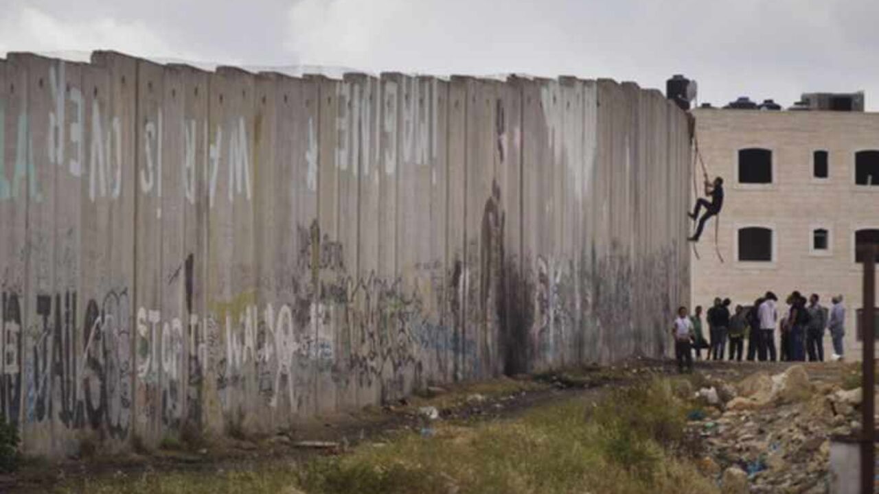 RAMALLAH, WEST BANK - MAY 15: A Palestinian youth climbs Israel's separation wall during clashes with the Israeli army during Nakba day on May 15, 2013 near the Qalandia checkpoint at the outskirts of Ramallah, the West Bank. Palestinians mark Israel's establishment in 1948 with 'Nakba' or 'catastrophe' day on May 15, to remember the thousands of Palestinians who fled or were expelled during the creation of the Jewish state and the subsequent war. (Photo by Uriel Sinai/Getty Images)