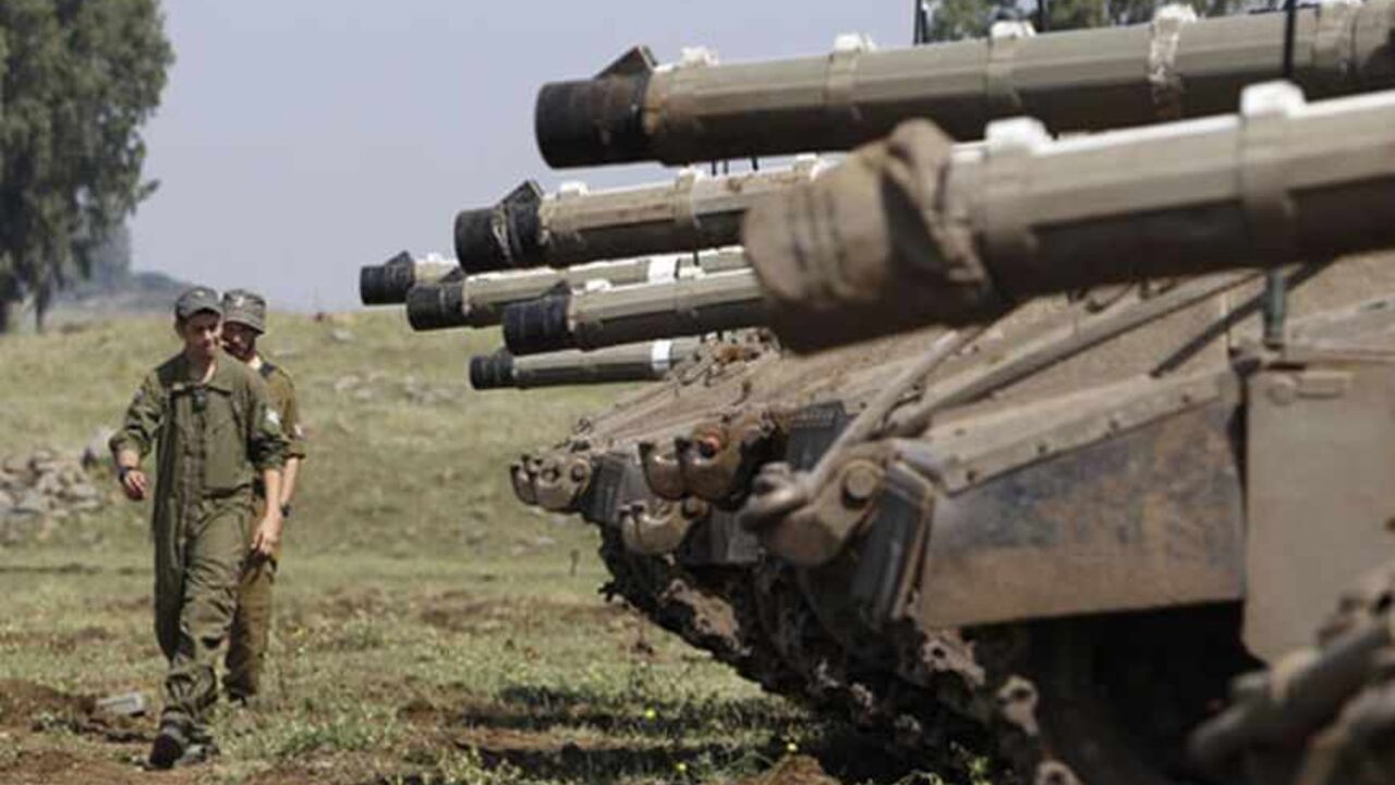 Israeli soldiers walk near tanks close to the ceasefire line between Israel and Syria on the Israeli occupied Golan Heights May 6, 2013. Israel sought to persuade Syrian President Bashar al-Assad on Monday that its recent air strikes around Damascus did not aim to weaken him in the face of a more than two-year-old rebellion. REUTERS/Baz Ratner (ISRAEL - Tags: POLITICS MILITARY) - RTXZC64