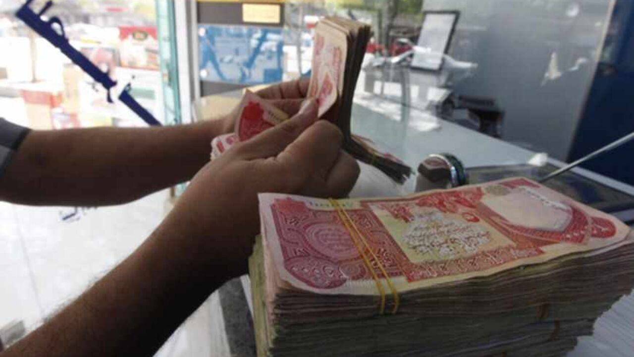 A customer counts Iraqi dinars at a money changer in Baghdad October 1, 2012. Many Iraqis have lost faith in their dinar currency but to some foreign speculators, it promises big profits. The contrast underlines the uncertainties of investing in Iraq as the country recovers from years of war and economic sanctions. Picture taken October 1, 2012. To match IRAQ-ECONOMY/DINAR  REUTERS/Saad Shalash (IRAQ - Tags: BUSINESS POLITICS) - RTR38QU1